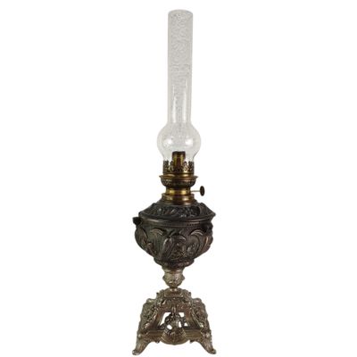 an old fashioned oil lamp with a glass shade on it