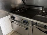 une cuisine équipée d'appareils électroménagers en inox et d'un sol carrelé