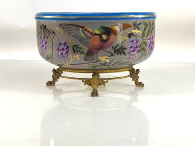 a bowl with a bird painted on it sitting on a stand