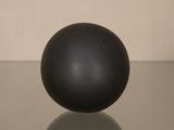 une boule noire posée sur une table en verre