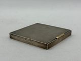 an antique silver cigarette case with a gold bar on the front