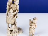 two figurines of people and a cat on a table