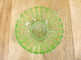 a green glass bowl sitting on a wooden table