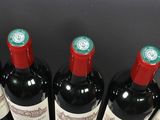 several bottles of wine are lined up on a black table