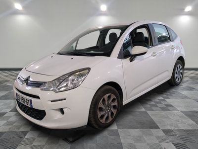la petite voiture blanche est garée sur un carrelage à carreaux