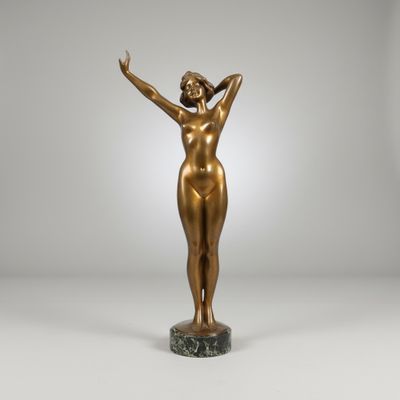 a bronze statue of a woman standing on a marble base