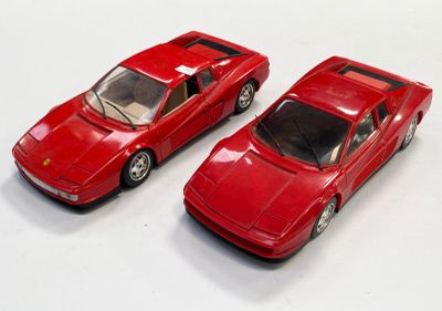 deux petites voitures rouges posées l'une à côté de l'autre sur une surface blanche
