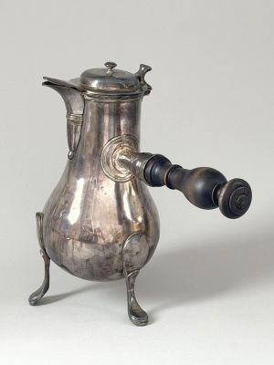 a silver coffee pot with a wooden handle on a stand