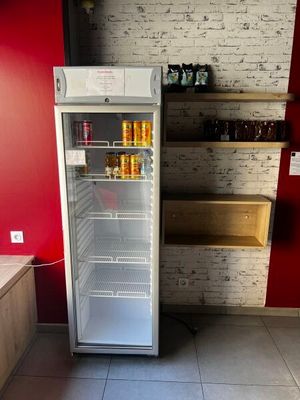 une photo d'un réfrigérateur dans une cuisine dont le mur est rouge