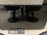 a flat screen tv sitting on the floor next to a remote control