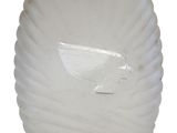 un vase blanc orné d'un poisson, posé sur une table