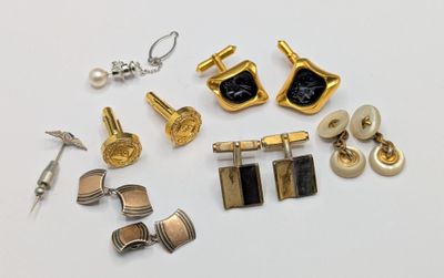 many different types of cufflinks and earrings on a white surface