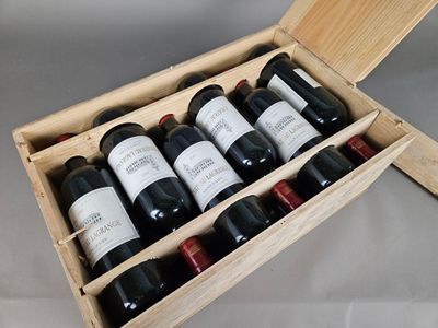bottles of wine are in a wooden box on a table
