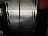 un grand réfrigérateur en acier inoxydable dans le coin d'une pièce