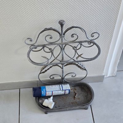 a toothbrush and toothpaste in a metal holder on the floor