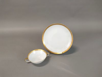 a white and gold cup and saucer on a gray surface