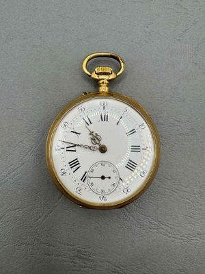 a gold pocket watch with roman numerals on the face