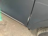 a close up of a car ' s side door with a hole in it
