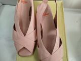 pair of women ' s pink shoes on a box on a white surface