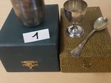 une tasse et une cuillère en argent posées sur une boîte