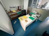 a desk with a computer and a chair in a room