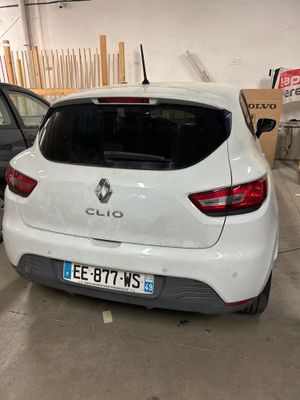 l'arrière d'une voiture blanche garée dans un garage à côté d'autres voitures