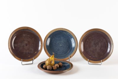 trois assiettes posées sur un porte-assiettes
