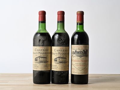three bottles of wine sitting on top of a wooden table