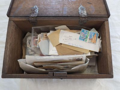 une boîte en bois remplie de lettres et d'enveloppes posée sur un lit