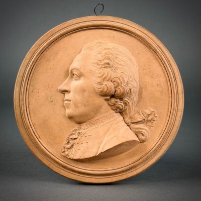 portrait of a man in profile on a circular plaque