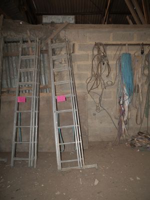 several ladders are leaning against a wall in an unfinished room