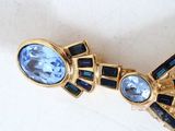 a gold brooch with blue stones on it