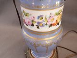 a blue vase with gold trim and flowers on it