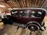 une vieille voiture qui prend la poussière dans un garage