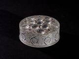 an ornate silver box with a flower design on it on a black surface