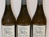trois bouteilles de vin sont alignées sur une surface blanche