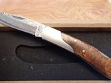 un couteau dans une boîte en bois posée sur une table