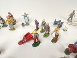 many figurines of people that are on a white surface