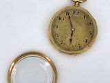 a gold pocket watch and a magnifying glass on a white surface