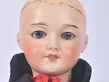 a close up of a doll wearing a jacket and tie