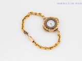 an image of a gold wrist watch with a chain around it