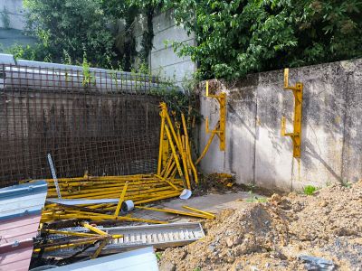 un tas de matériaux de construction posé par terre à côté d'une clôture