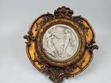 un cadre doré richement décoré, dans lequel figure le portrait d'une femme et d'un enfant