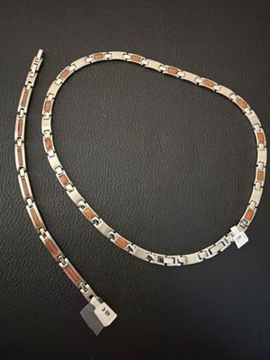 a close up of a silver and gold bracelet on a black surface