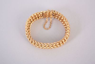 a close up of a gold chain bracelet on a white surface