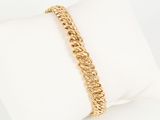 a close up of a gold chain bracelet on a white pillow