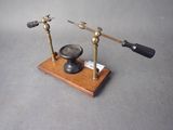 une petite horloge posée sur un socle en bois, munie d'une poignée noire