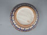 a blue and white bowl with a gold rim on a table