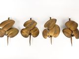 quatre figurines en laiton de tailles et de formes différentes posées sur une surface blanche