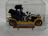 a toy car in a clear box on a white surface